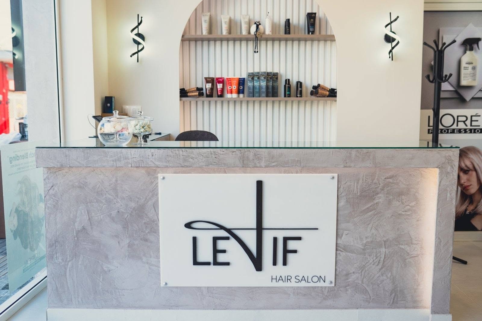 Υποδοχή του LETIF Hair Salon με την επωνυμία στον πάγκο και ράφια με προϊόντα