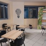 Αίθουσα με ατομικά θρανία και διακοσμητική πόρτα με βιβλία