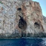 Βραχώδης ακτή με σπηλιές στη διαδρομή της εκδρομής με σκάφος της Smile Cruises